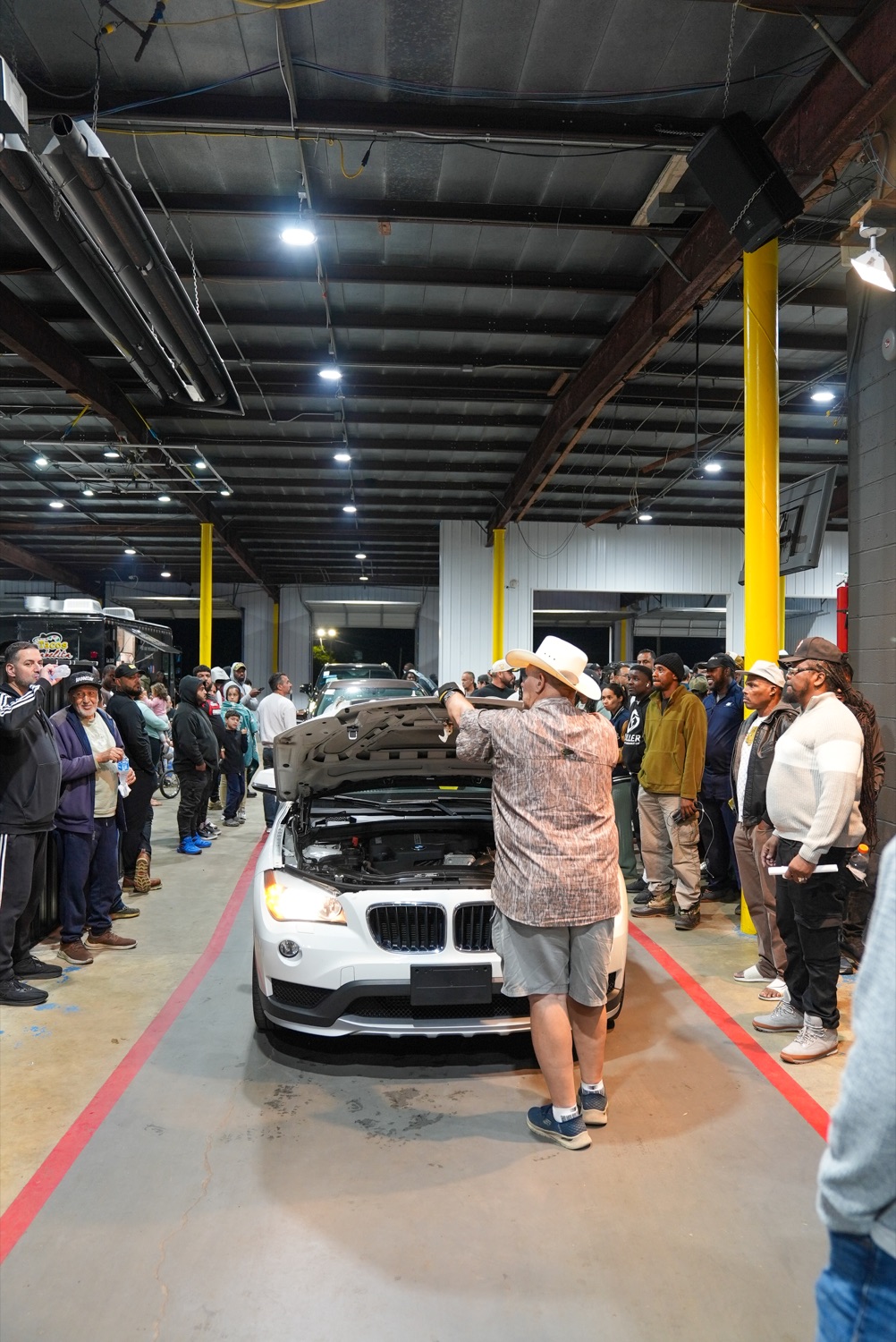 A white BMW being presented to a crowd of buyers in the Delaware Auto Exchange auction lane